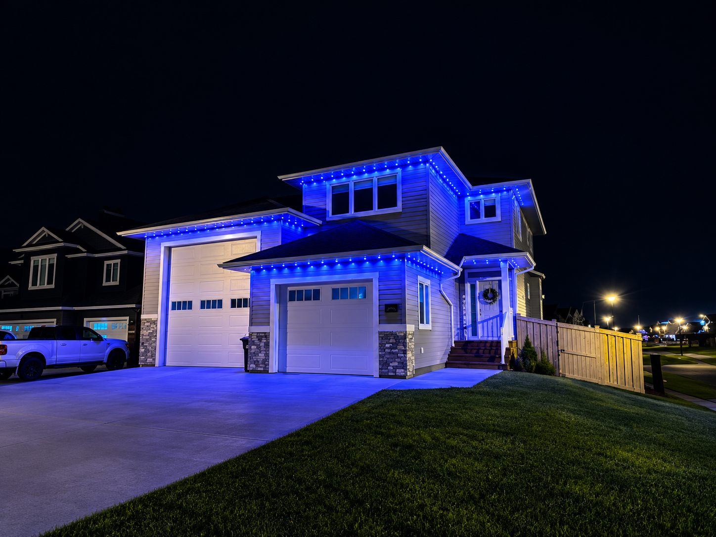 Two-storey home with blue permanent lights along the eaves